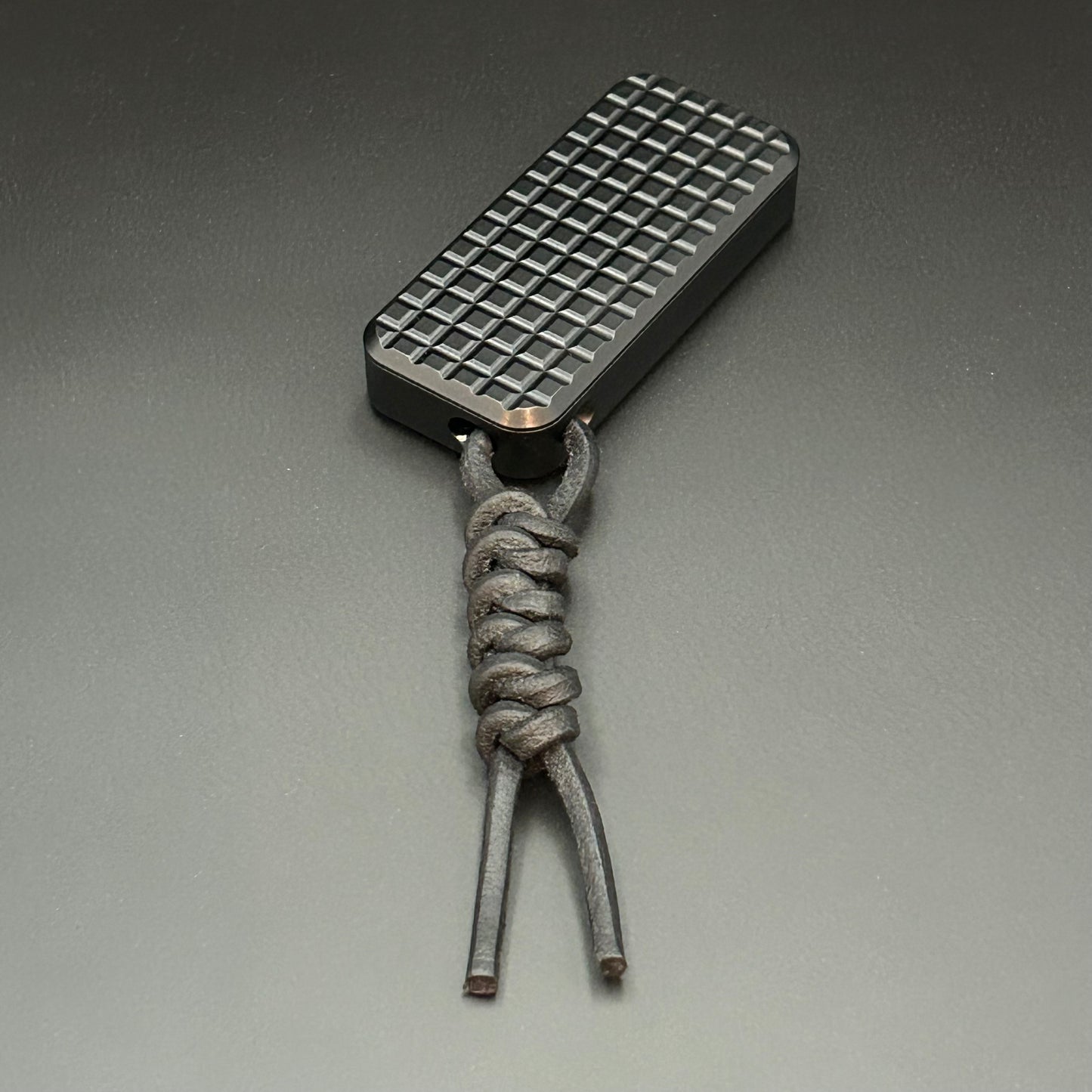 Black leather lanyard tied to Rivery Zero Knife, with blade retracted