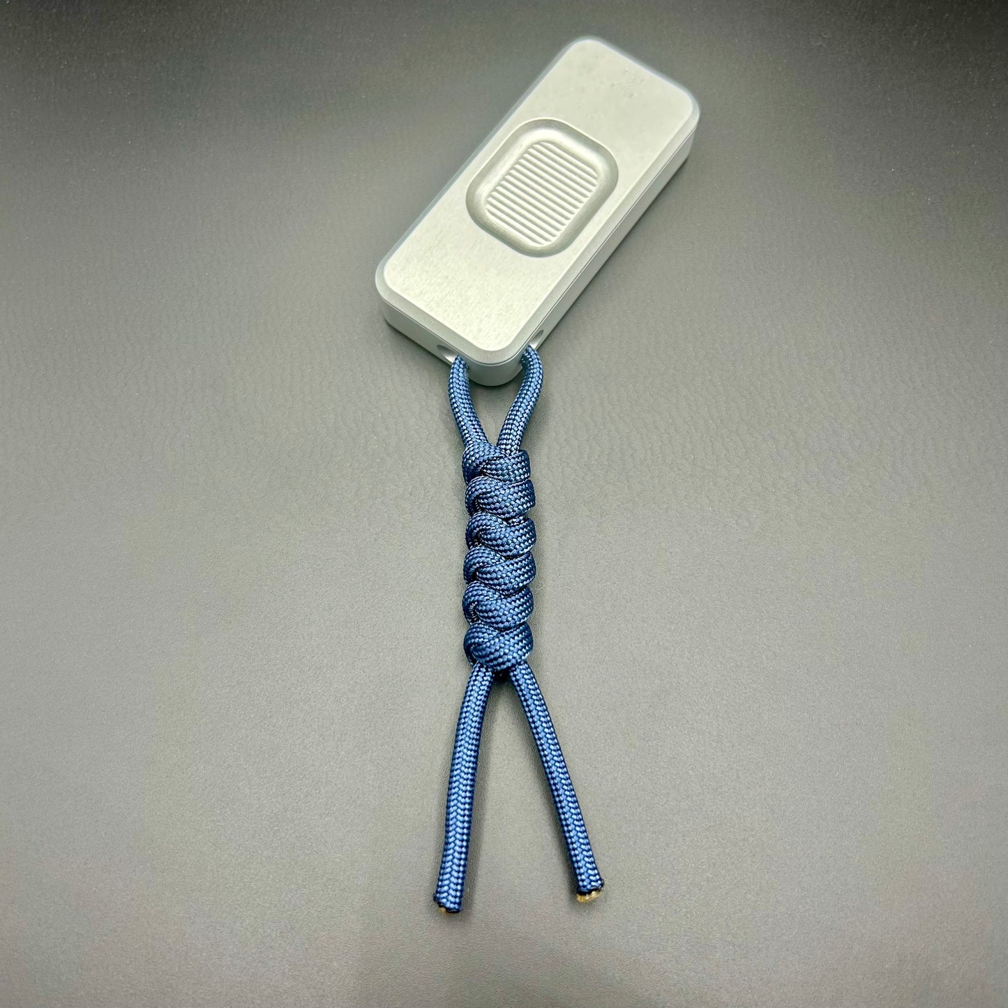 Blue paracord lanyard tied to Rivery Zero Knife, with blade retracted