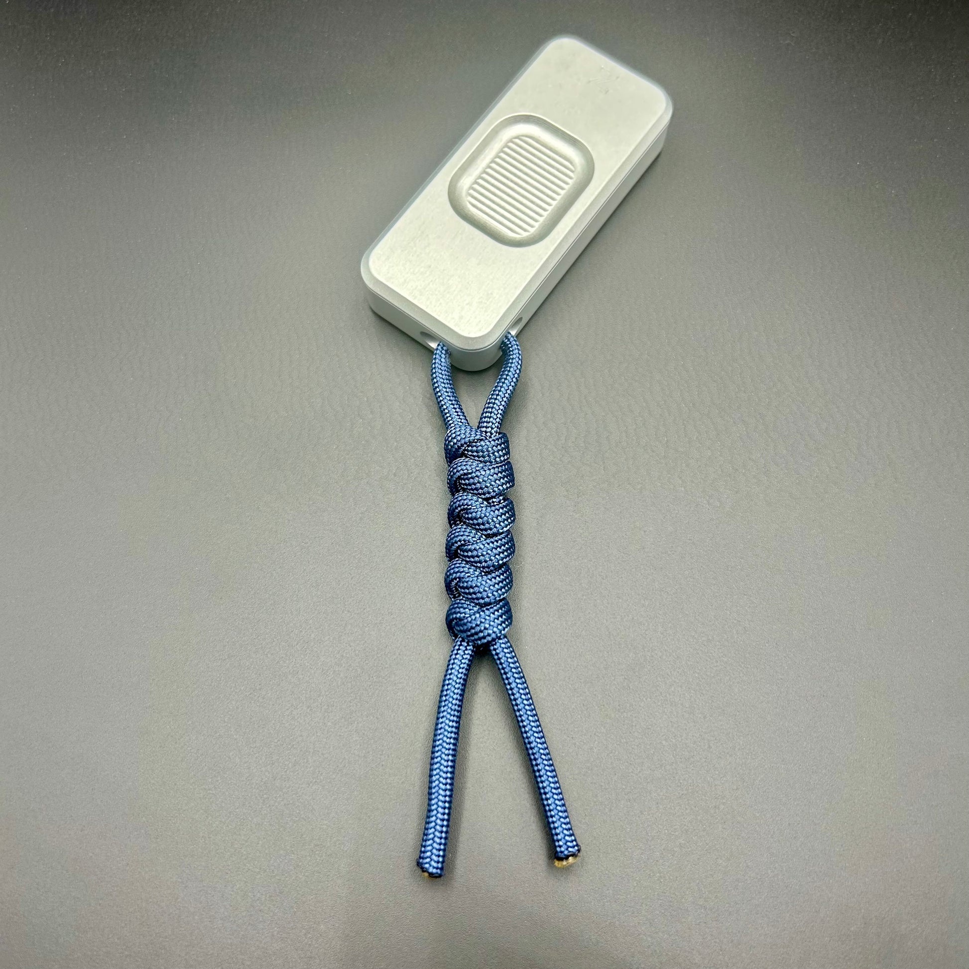 Blue paracord lanyard tied to Rivery Zero Knife, with blade retracted