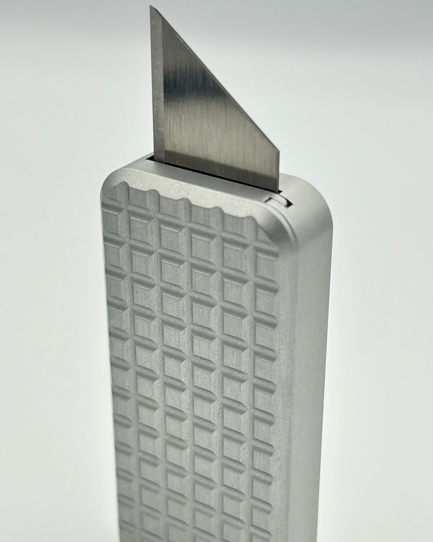 Grenade Grey Aluminium Zero knife standing vertically with blade exposed