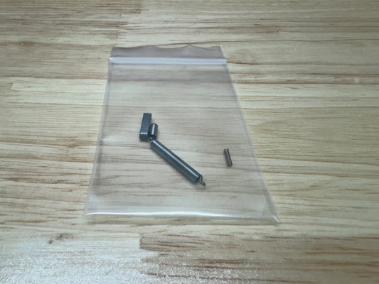 Four small metal objects in a clear plastic bag on a wooden surface