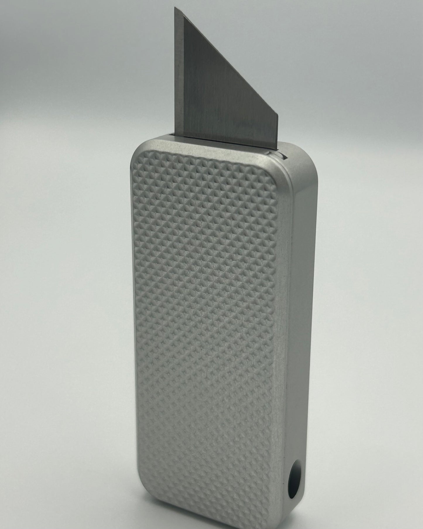 Knurled Zero knife standing vertically with blade exposed