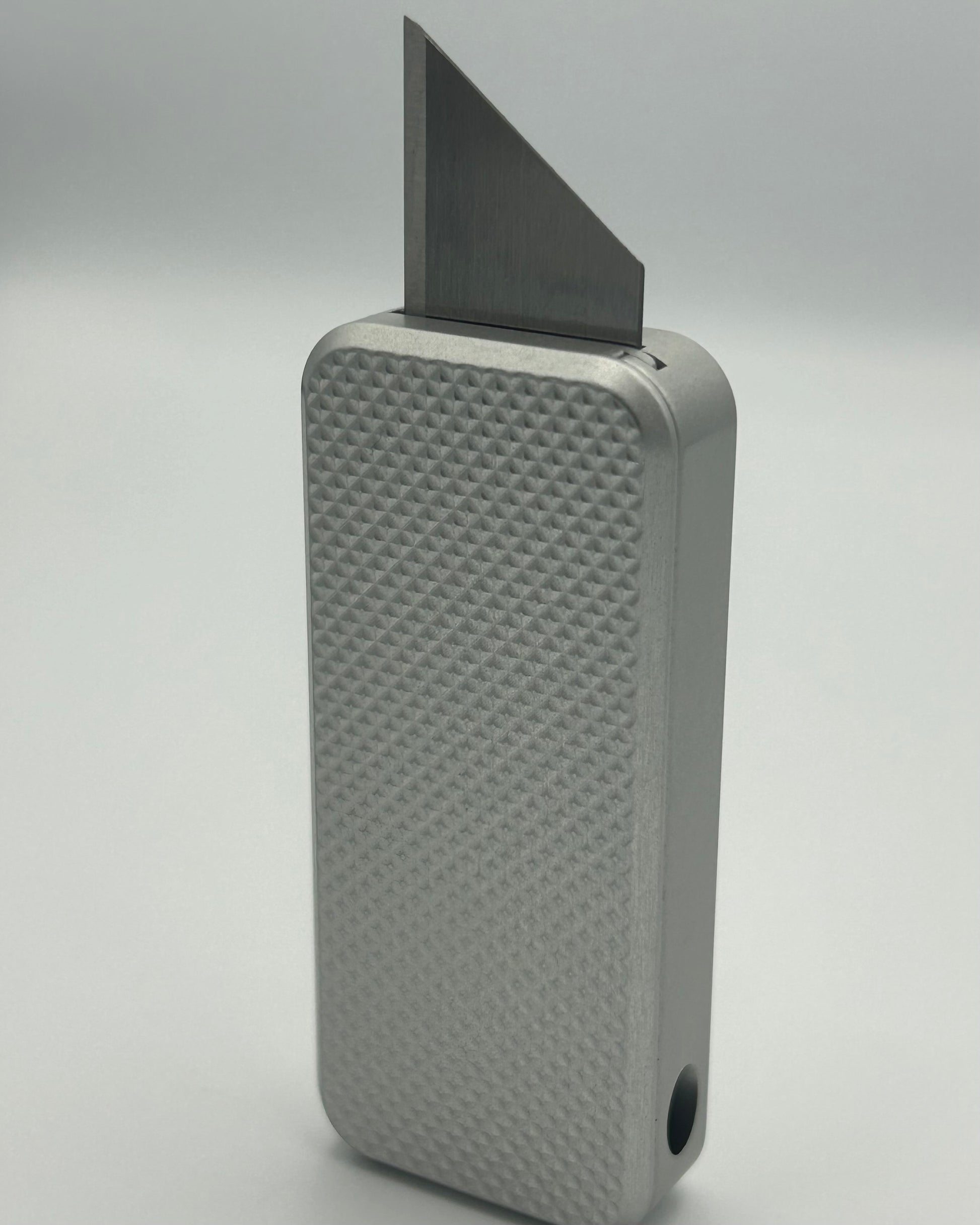 Knurled Zero knife standing vertically with blade exposed