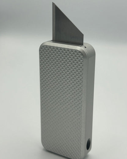 Knurled Zero knife standing vertically with blade exposed
