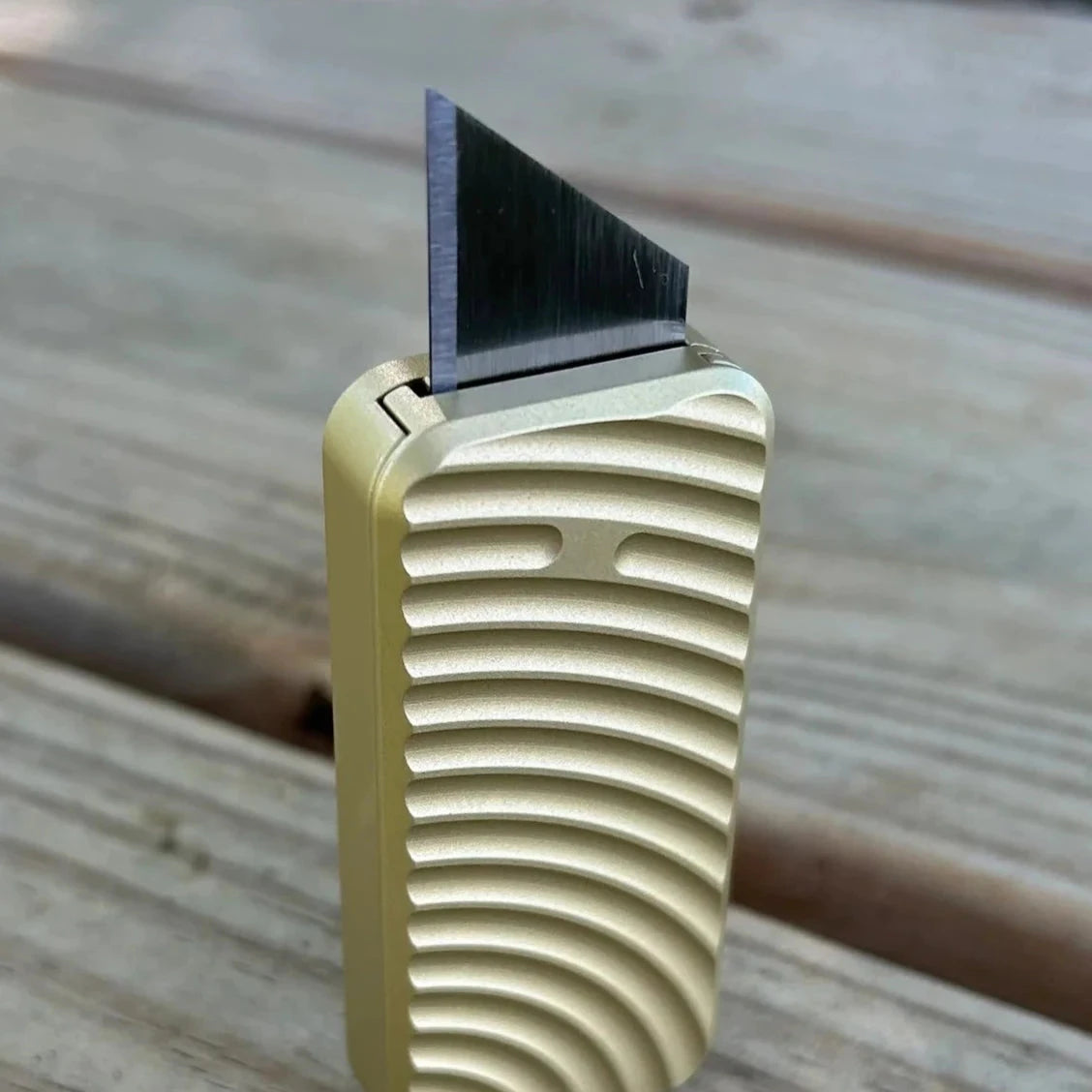 Gold Rivery Zero knife with Original pattern on a wooden surface showing blade extended