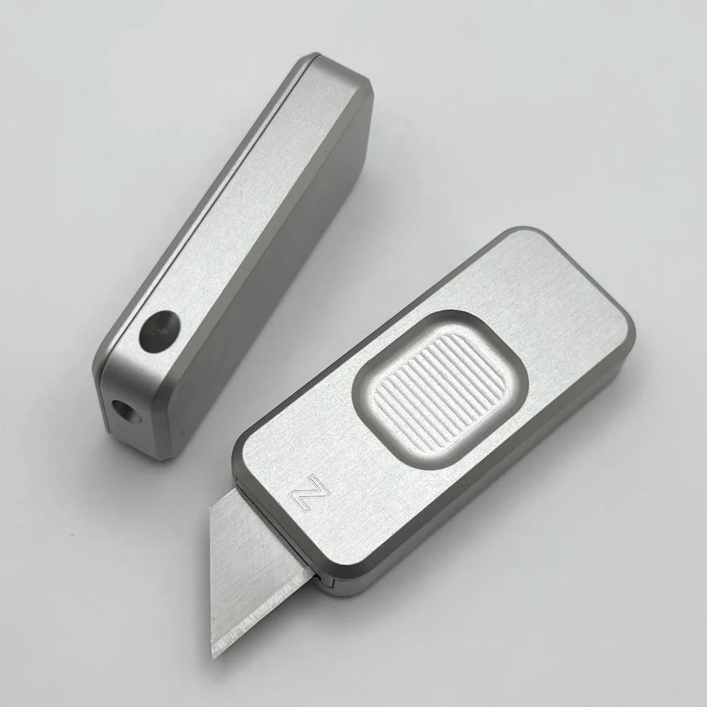 Two Zero knives next to each other, one with blade showing and the other with blade retracted, displayed on a white background