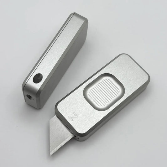 Two Zero knives next to each other, one with blade showing and the other with blade retracted, displayed on a white background